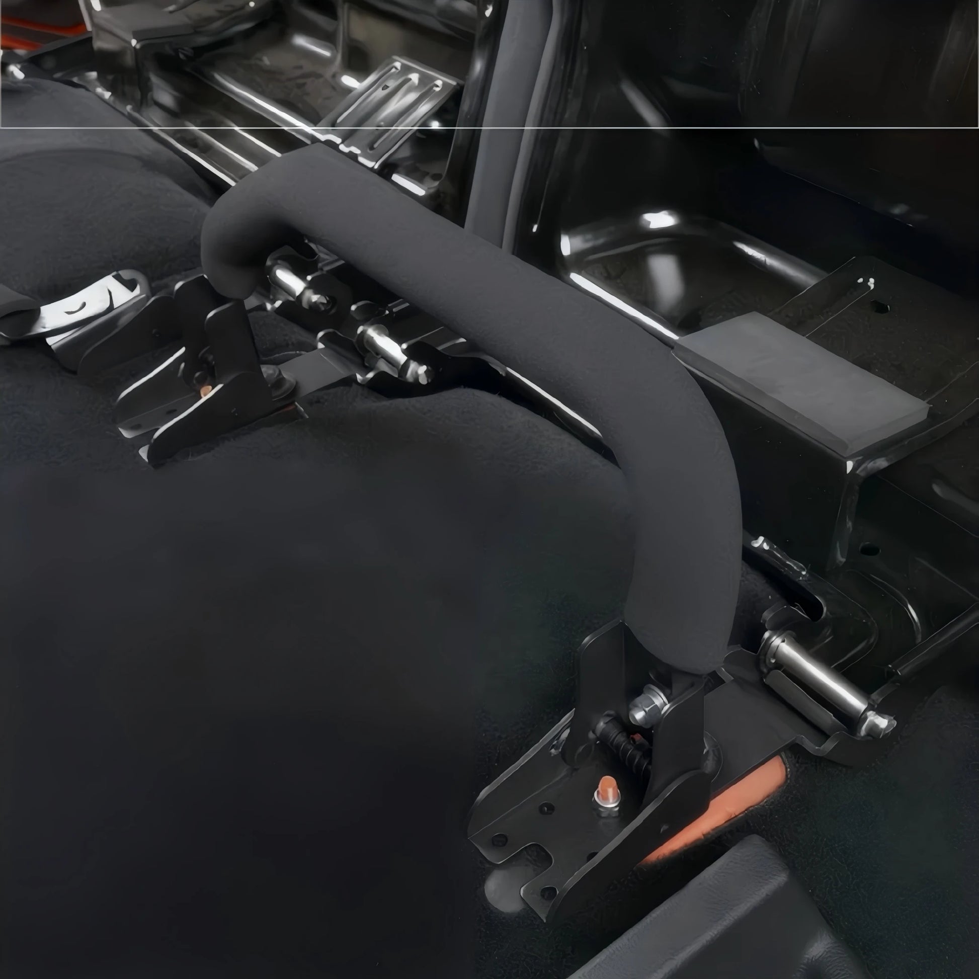 Close-up view of a single black quick-release seat bracket with a foam-covered handle installed on the vehicle floor.