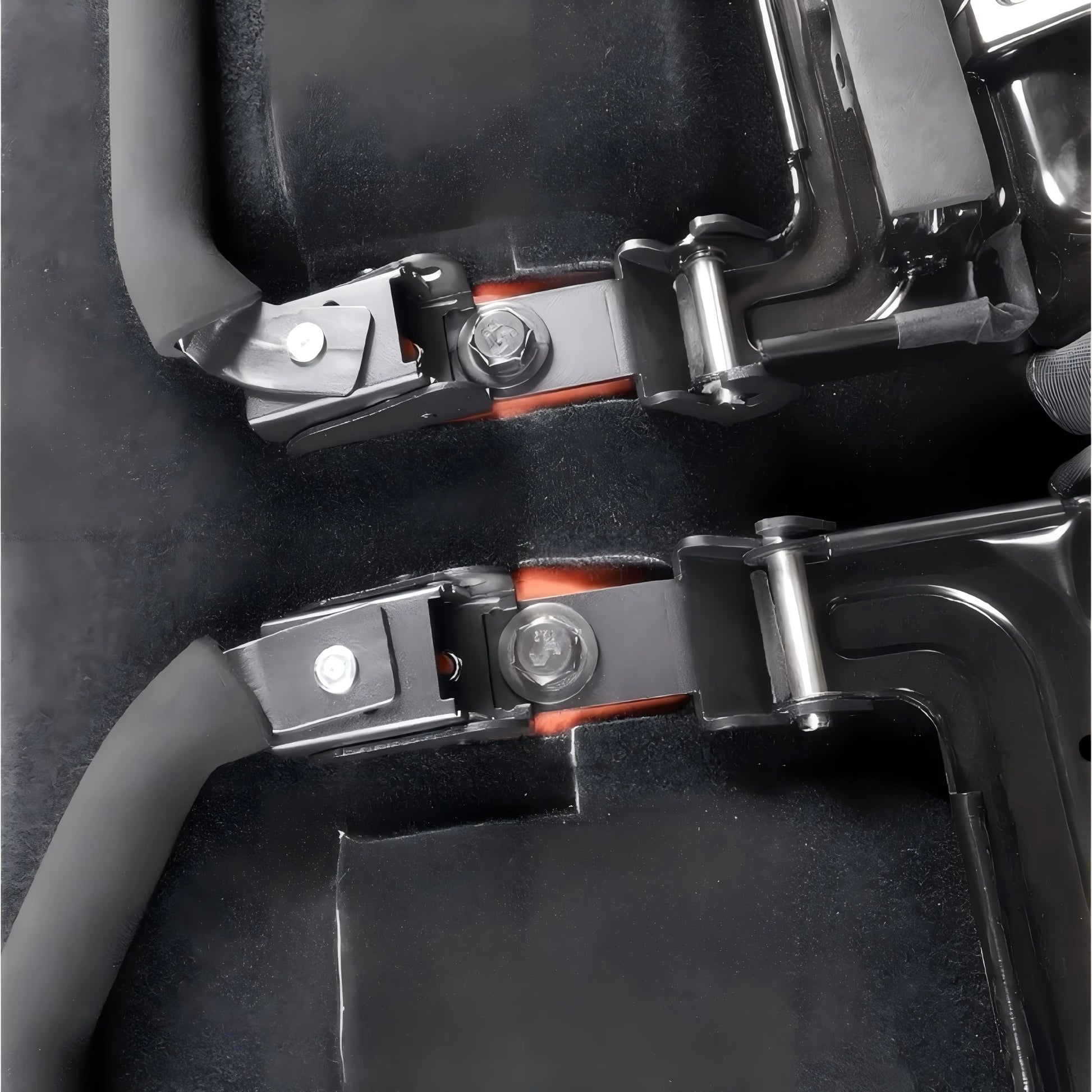 Close-up of the quick-release bracket hardware and mounting pins installed on a vehicle's rear seat structure.