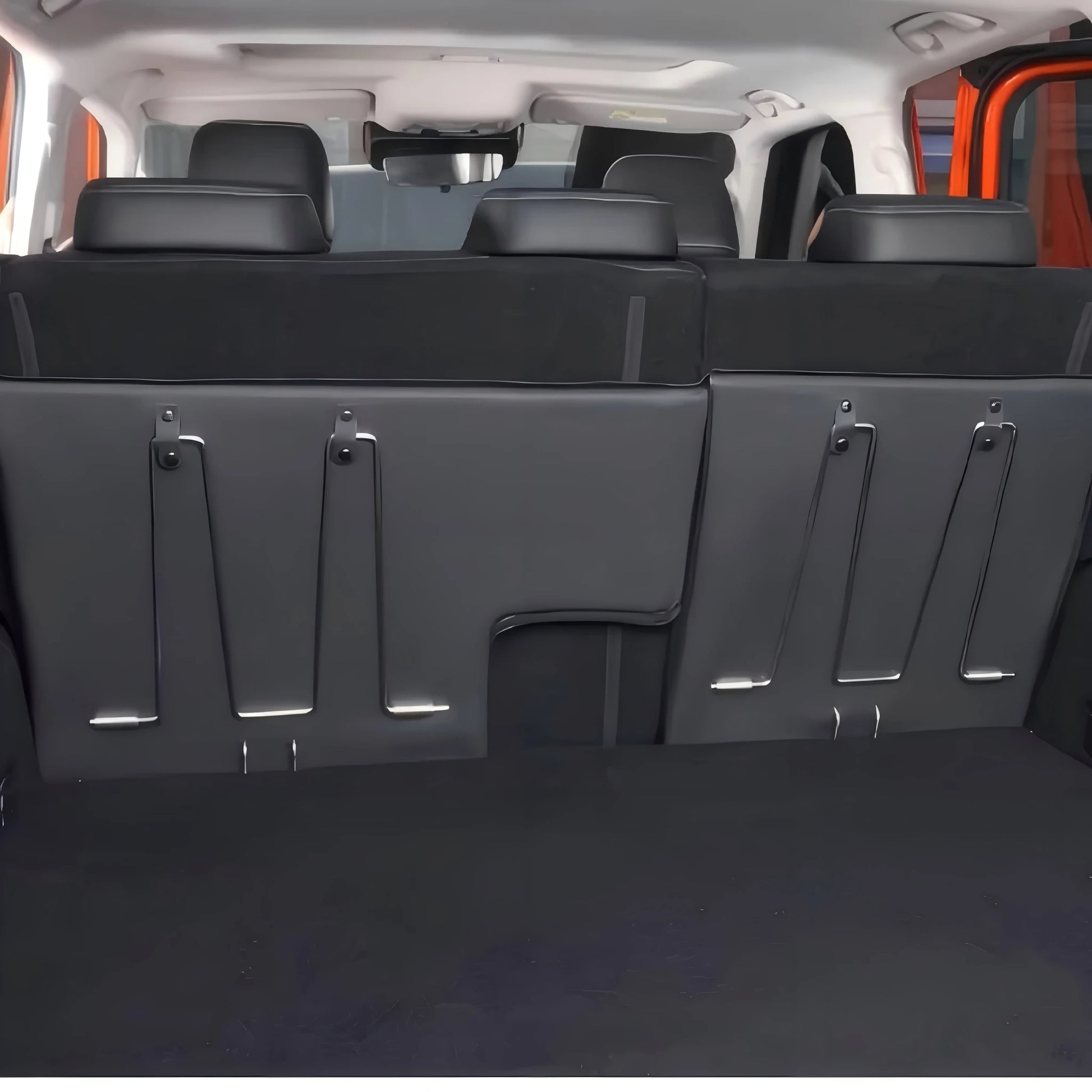 View of foldable steel support legs integrated into the back of a vehicle's rear seats for bed extension stability.
