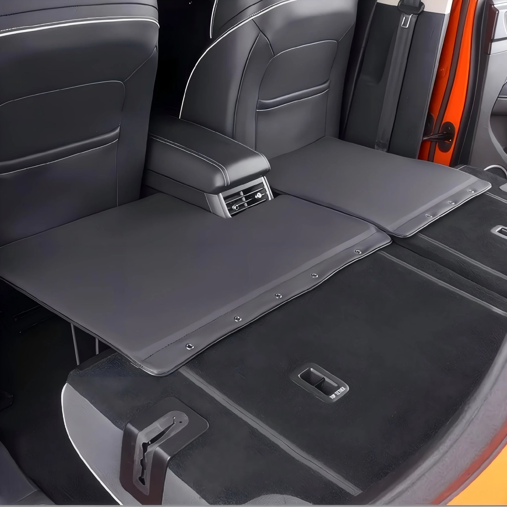 Interior view showing a two-piece travel bed extension installed over the rear passenger footwell.
